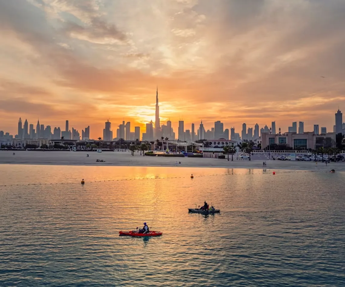 Dubai skyline glowing at sunset across the water