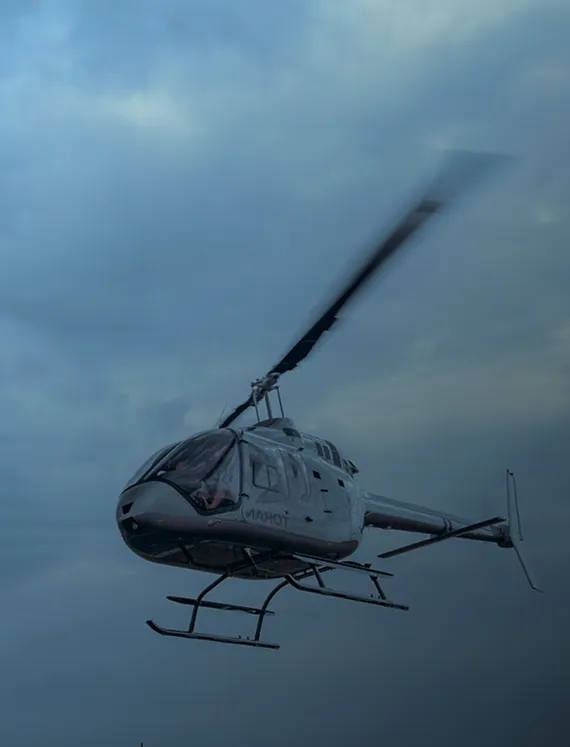 Helicopter in flight against a moody evening sky