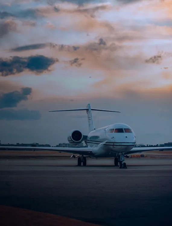 Private jet on the tarmac beneath a dusk sky