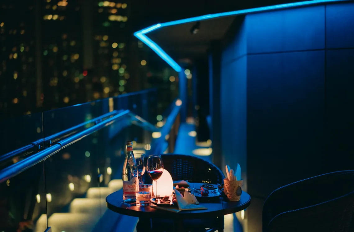 Reserved rooftop table at an exclusive nightclub overlooking the city at night
